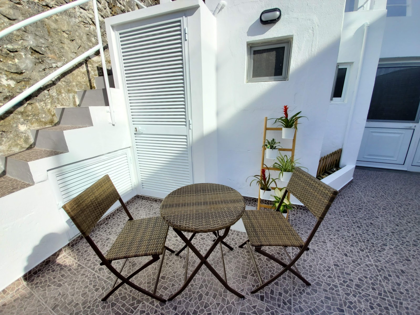 Patio at Cozy Beach House with small outdoor table and potted plants