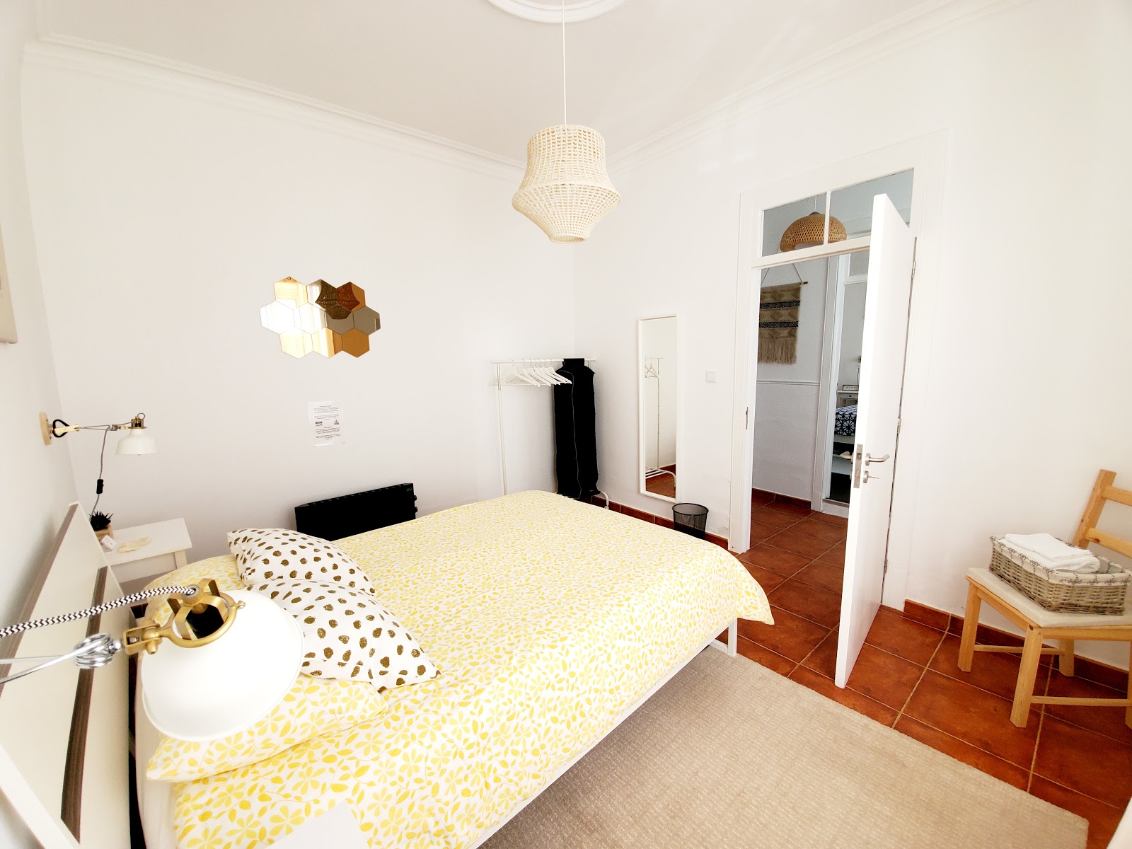 Bright bedroom with a double bed, curtains, and simple bedside lighting